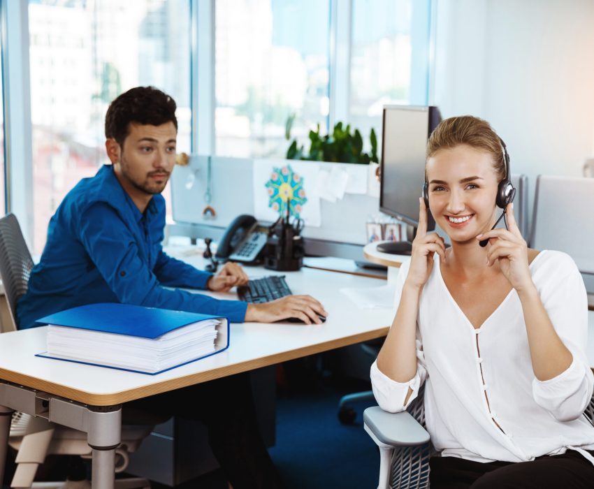 Young beautiful female support phone operator speaking, consulting, office background.